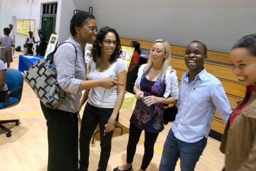 During a community event at Elizabeth Virrick Park, MarieGuerda Nicolas, left, associate professor of educational and psychological studies in the School of Education, speaks with some of the UM student mentors and counselors involved in the Kulula Project.