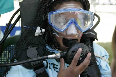 Lakeria Gathers, of Liberty City Elementary School, breathes through a dive regulator at the "Underwater Adventures" station.