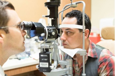 Bascom Palmer's Guillermo Amescua, left,  examines the eye of Juan Aguirre.