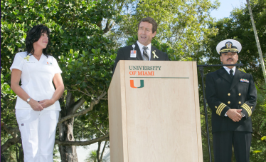 University of Miami Hospital CEO Dan Snyder introduces fellow  veterans and UMH employees Monica Perez, left, and Julio Albornez, right.