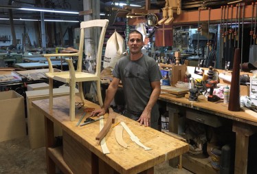 Austin matheson works on the prototype of what would beciem theThe Univerisyt of Miami Presidential Chair in his mimi a woofurniute-makign shop. 