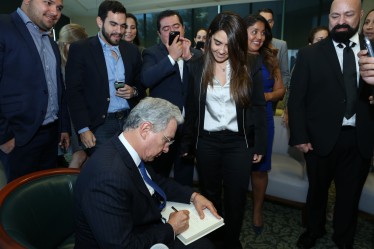 Colombian Senator Alvaro Uribe signs books for students.